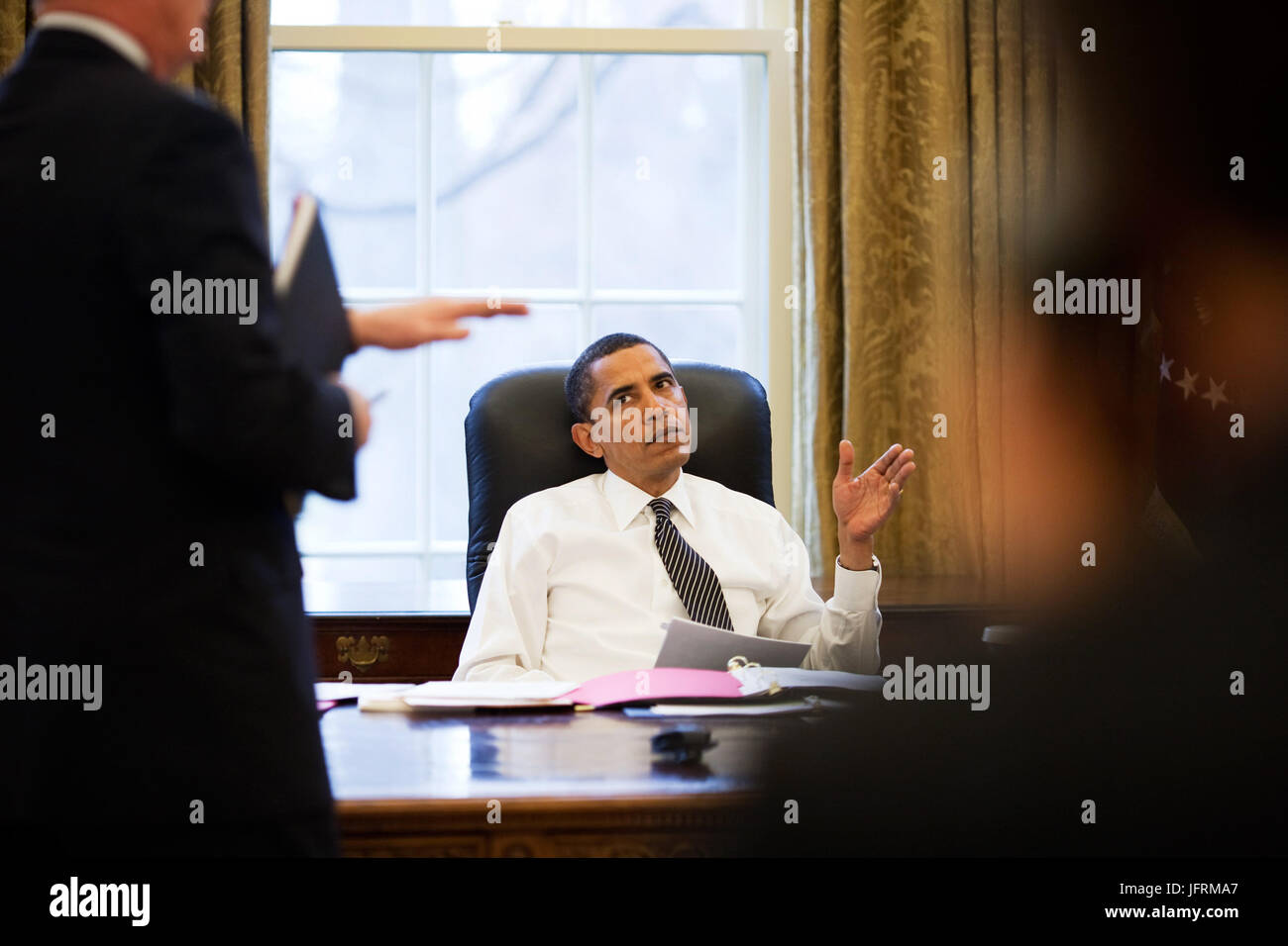 Le président Barack Obama est informé avant de faire des appels téléphoniques avec les dirigeants étrangers dans le bureau ovale 1/26/09. Photo Officiel de la Maison Blanche par Pete Souza Banque D'Images