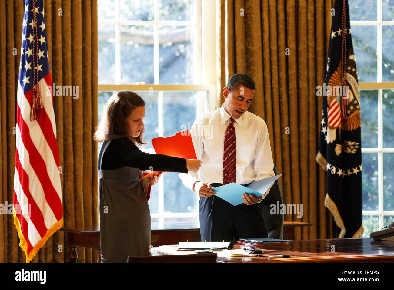 Le président Barack Obama se penche sur la correspondance quotidienne dans le bureau ovale avec son secrétaire personnel Katie Johnson 1/30/09. Photo Officiel de la Maison Blanche par Pete Souza Banque D'Images