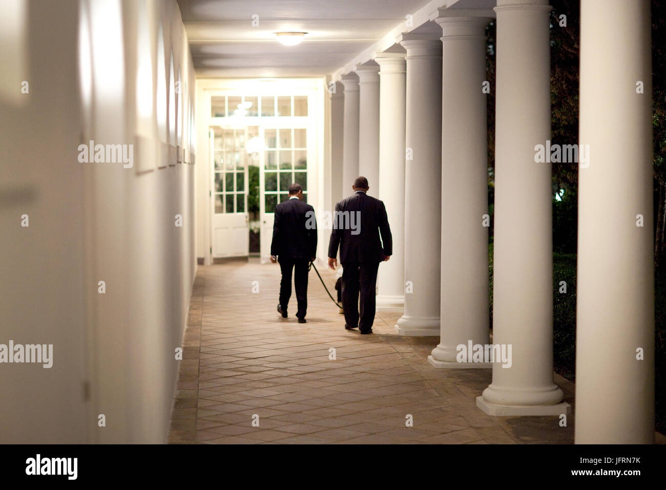 Le président Barack Obama quitte le bureau ovale la nuit, marcher avec leur chien, 'Bo', sur la colonnade vers la résidence 4/24/09 Photo Officiel de la Maison Blanche par Pete Souza Banque D'Images