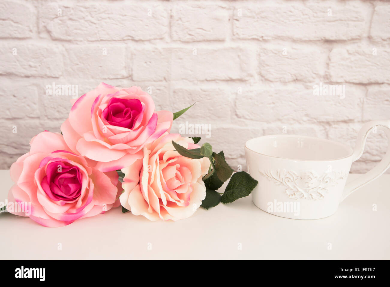 Bouquet de roses blanches sur un bureau, une grande tasse de café devant angel, arrière-plan floral romantique, style Floral Wall Maquette, maquette de Rose Banque D'Images