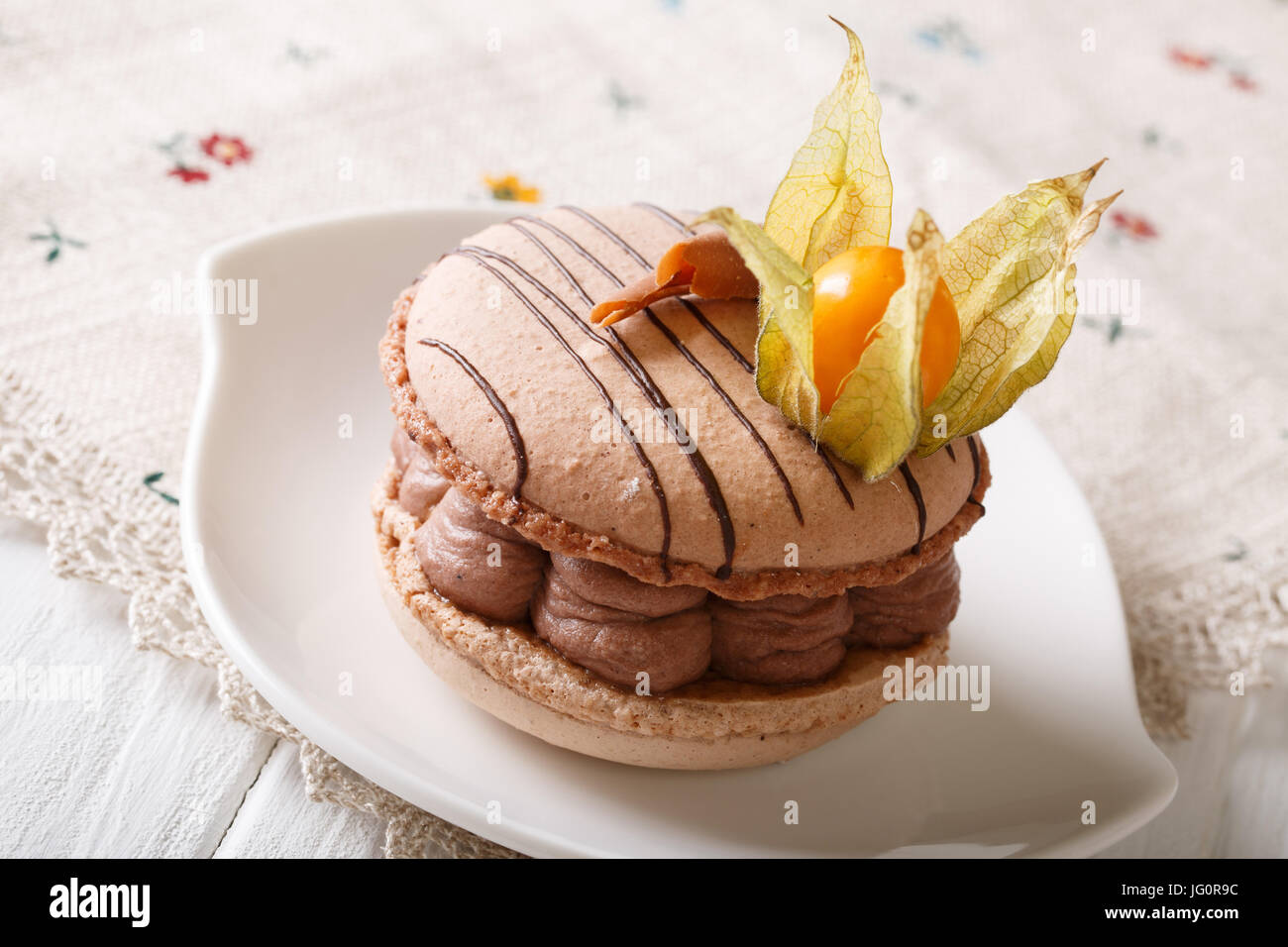 Dessert : macaron avec crème au chocolat décoré avec des physalis gros plan sur une plaque horizontale. Banque D'Images