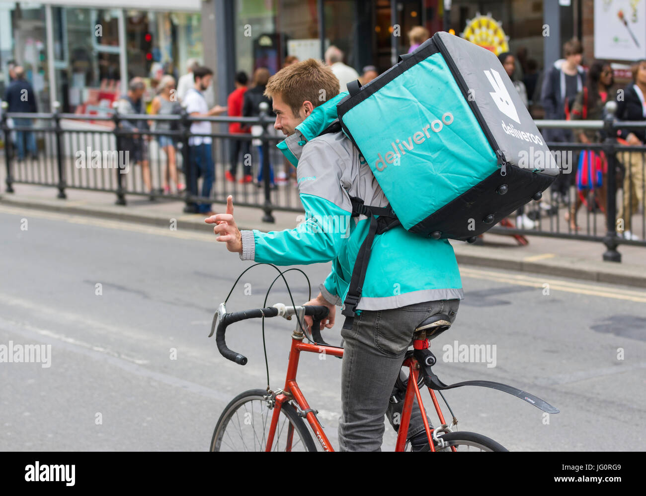 Deliveroo cycliste livraison de rouler à vélo dans une ville à Brighton, East Sussex, Angleterre, Royaume-Uni. Banque D'Images
