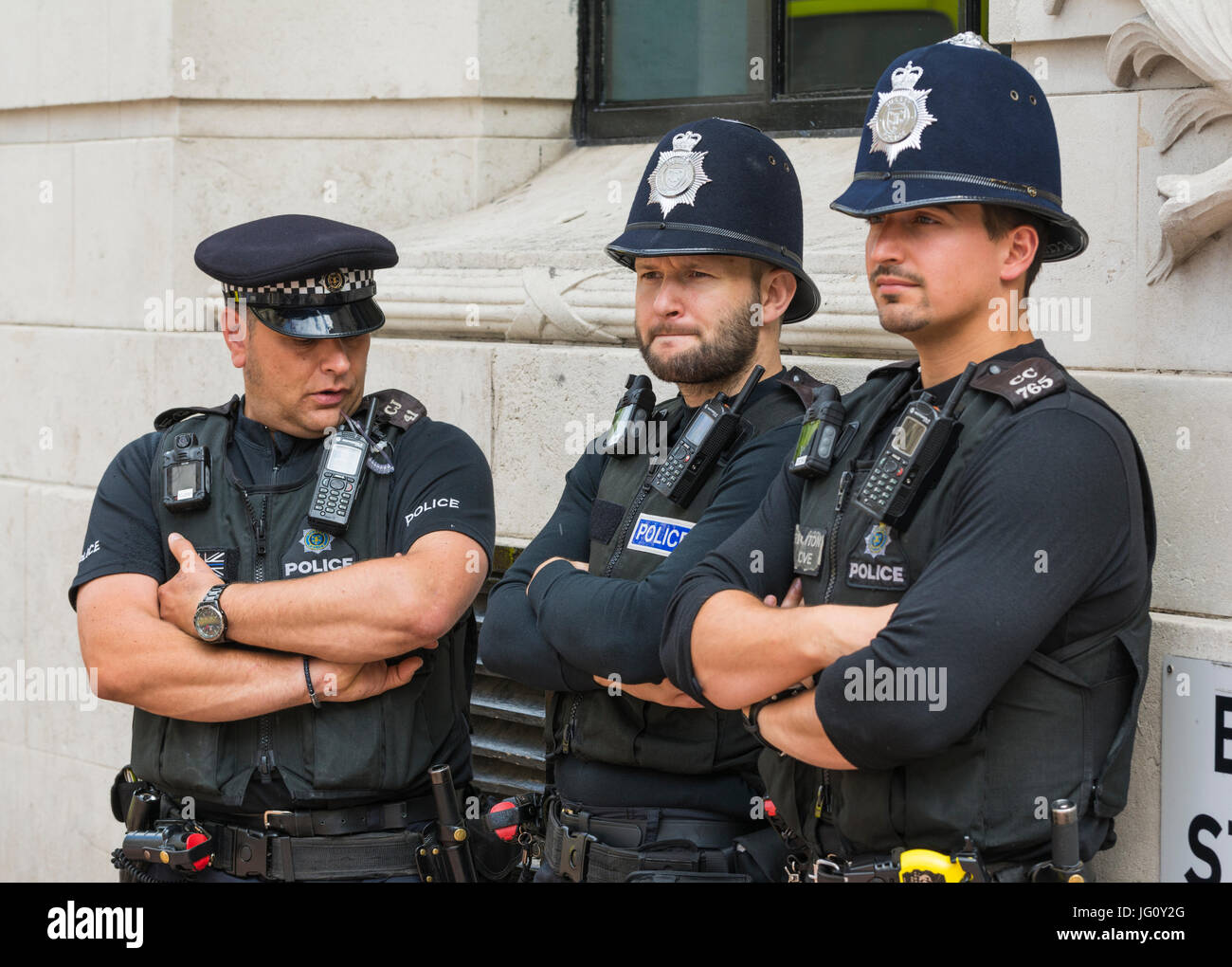 Les agents de police debout contre un mur lors d'un événement public dans le sud de l'Angleterre, Royaume-Uni. Banque D'Images