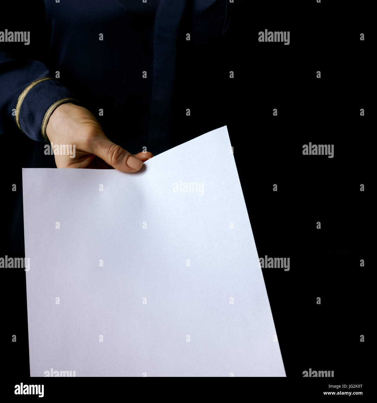 Main de femme Mania. noir isolé sur fond noir feuille de papier donnant Banque D'Images