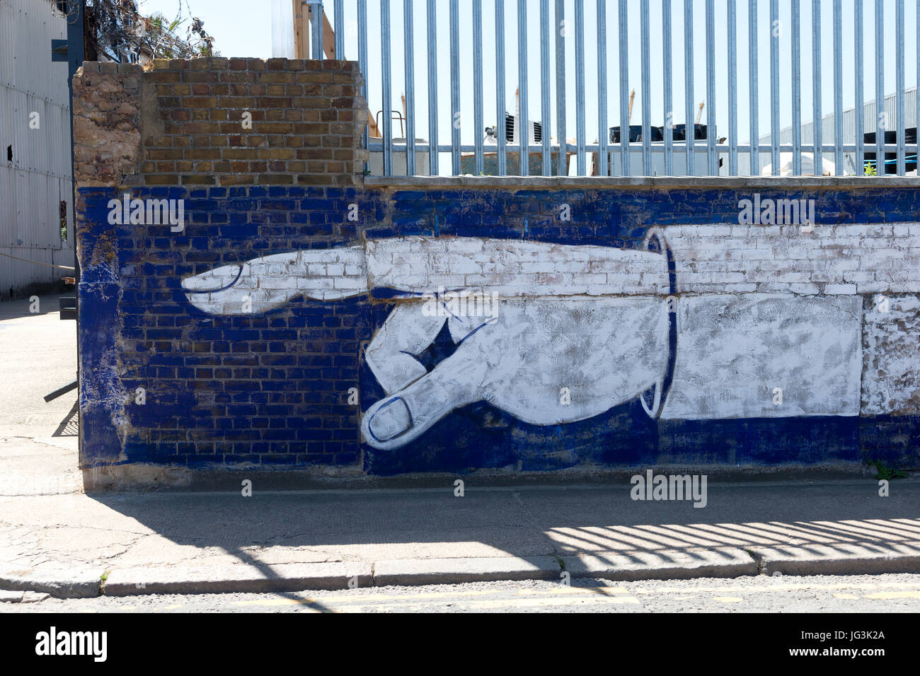 Doigt peint sur un mur de brique, Orchard Place, Tower Hamlets, London, England, UK. Banque D'Images