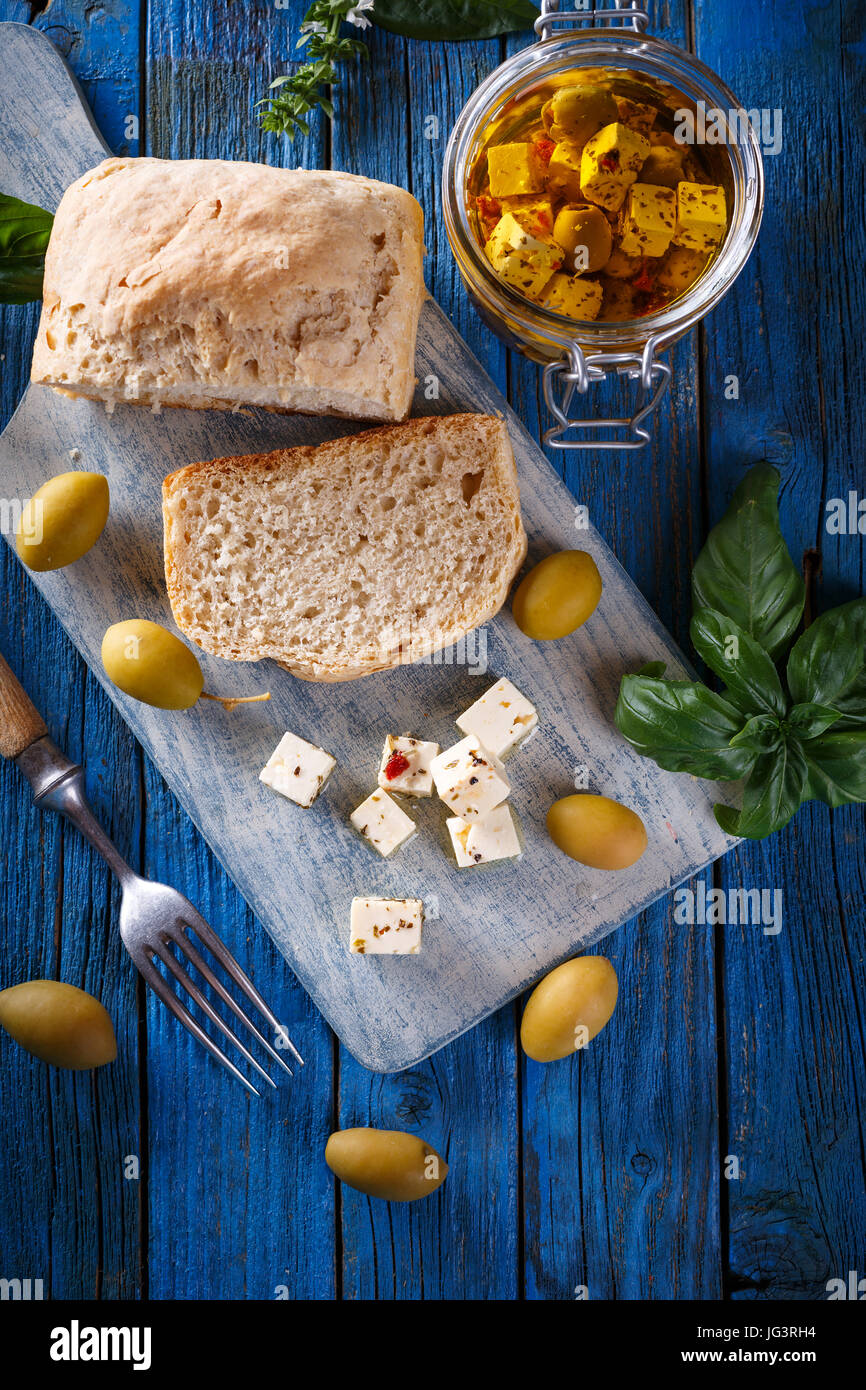 Cubes de fromage feta aux olives sur fond de bois bleu Banque D'Images