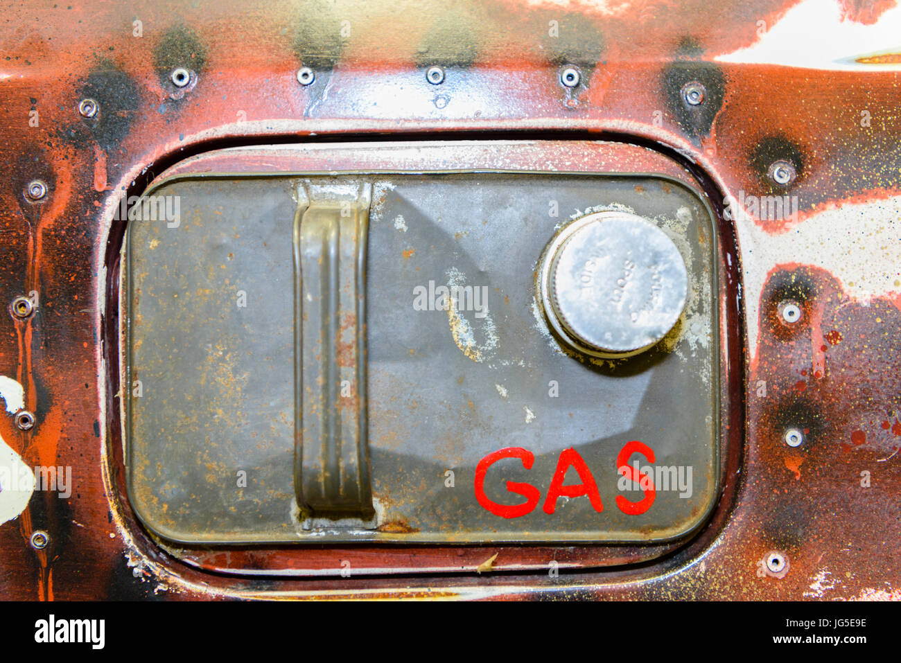 Haut d'une essence peut coincé sur la goulotte de remplissage de carburant d'une vieille voiture rouillée, avec rivets et "GAZ" écrit dessus. Banque D'Images