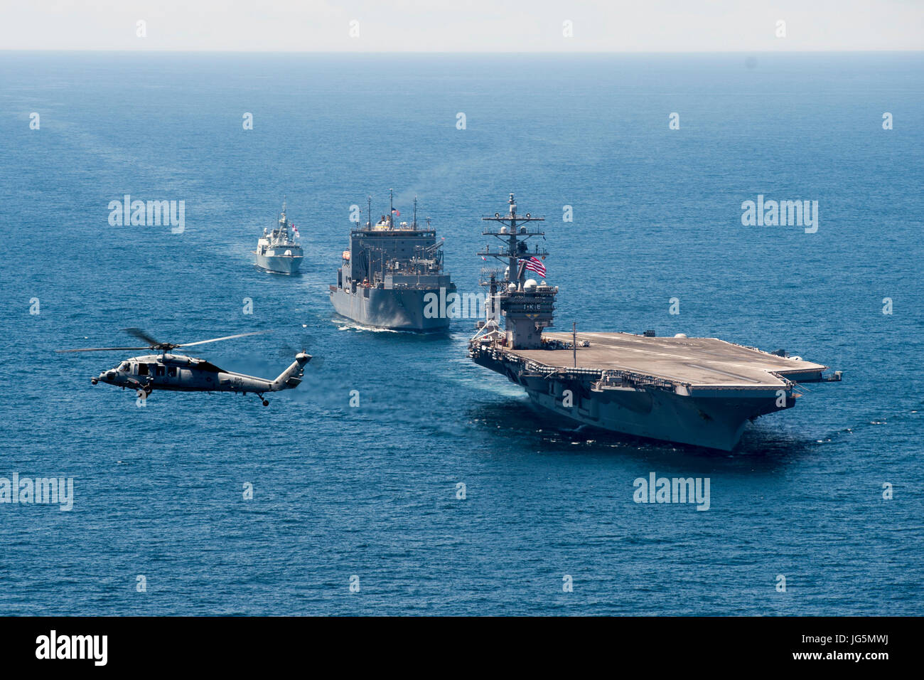 170627-N-YZ751-1537 de l'OCÉAN ATLANTIQUE (27 juin 2017) Un Sea Hawk MH-60S affecté à l'hélicoptère de chiens poussiéreux de l'Escadron de Combat de mer (HSC) 7 défile le porte-avions USS Dwight D. Eisenhower (CVN 69)(IKE), l'Armée Commande de transport maritime de marchandises et de munitions ship USNS Robert E. Peary (T-AKE 5), et la Marine royale canadienne frégate NCSM Charlottetown (FFH 339) au cours de l'exercice d'une photo. Ike est en cours d'un groupe bilatéral de la voile dans le cadre de la célébration de l'anniversaire du Canada 150. (U.S. Photo par marine Spécialiste de la communication de masse 1re classe Tony D. Curtis) Banque D'Images