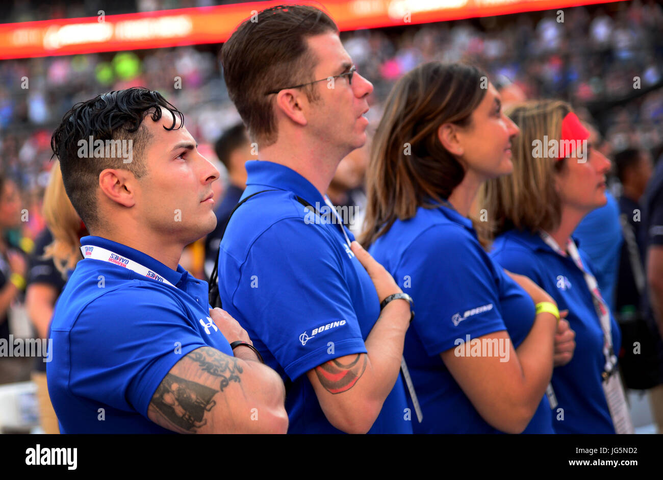 Le sergent de l'US Air Force. Vincent Cavazos, une troupe des forces de sécurité de Fresno, Californie, se dresse avec sa main sur son coeur avec ses coéquipiers durant l'hymne national au ministère de la Défense 2017 Cérémonie d'ouverture des Jeux de guerrier 1 Juillet, 2017 à Soldier Field, Chicago, Illinois Cavazos sera en compétition de tir à l'arc, athlétisme et natation pendant les jeux de cette année. (U.S. Photo de l'Armée de l'air par le sergent. Alexx Pons) Banque D'Images