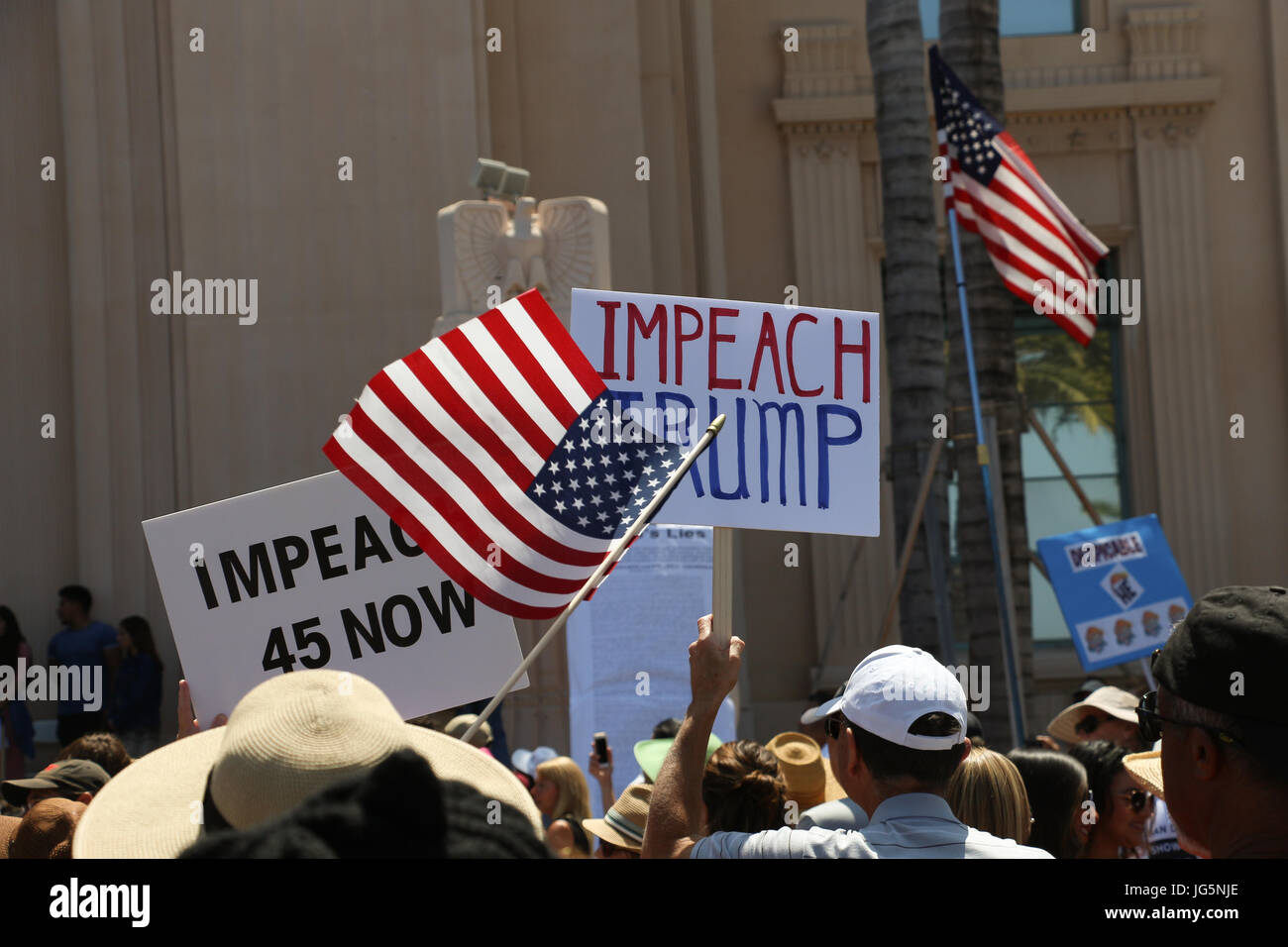 'Impeach Trump,' 'attaquer' maintenant 45 affiches et American drapeaux flottant au-dessus des têtes des manifestants à la destitution Mars à San Diego, CA, le 2 juillet. Banque D'Images