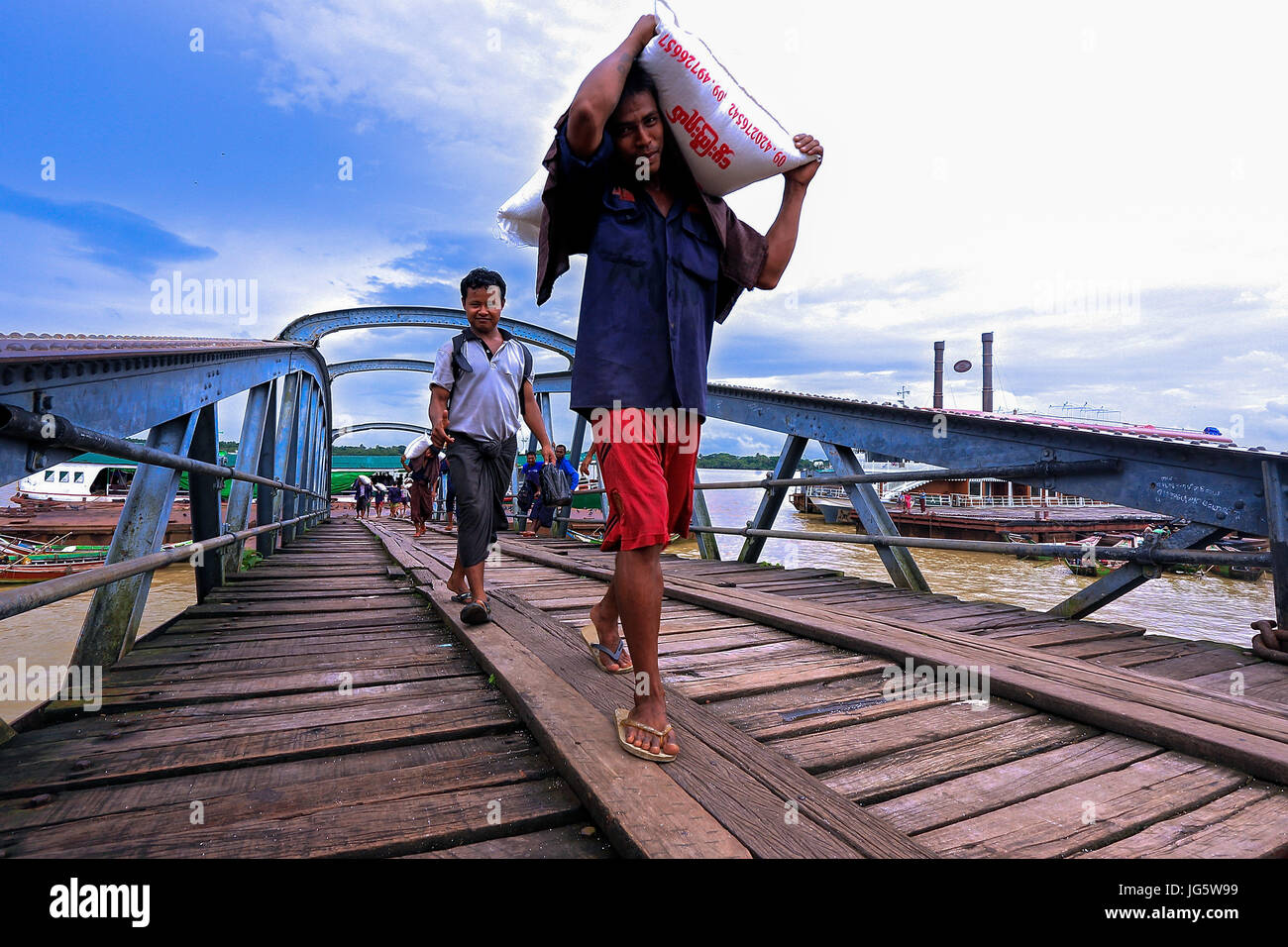 Le déchargement du fret provenant de travailleurs sur des bateaux en attente de camions à un quai à Yangon, Myanmar Banque D'Images