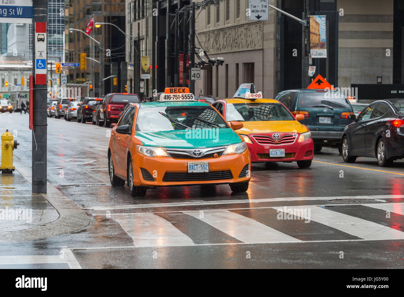 Toronto, Canada - 26 juin 2017 : 2 taxis dans le centre-ville de Toronto un jour de pluie Banque D'Images