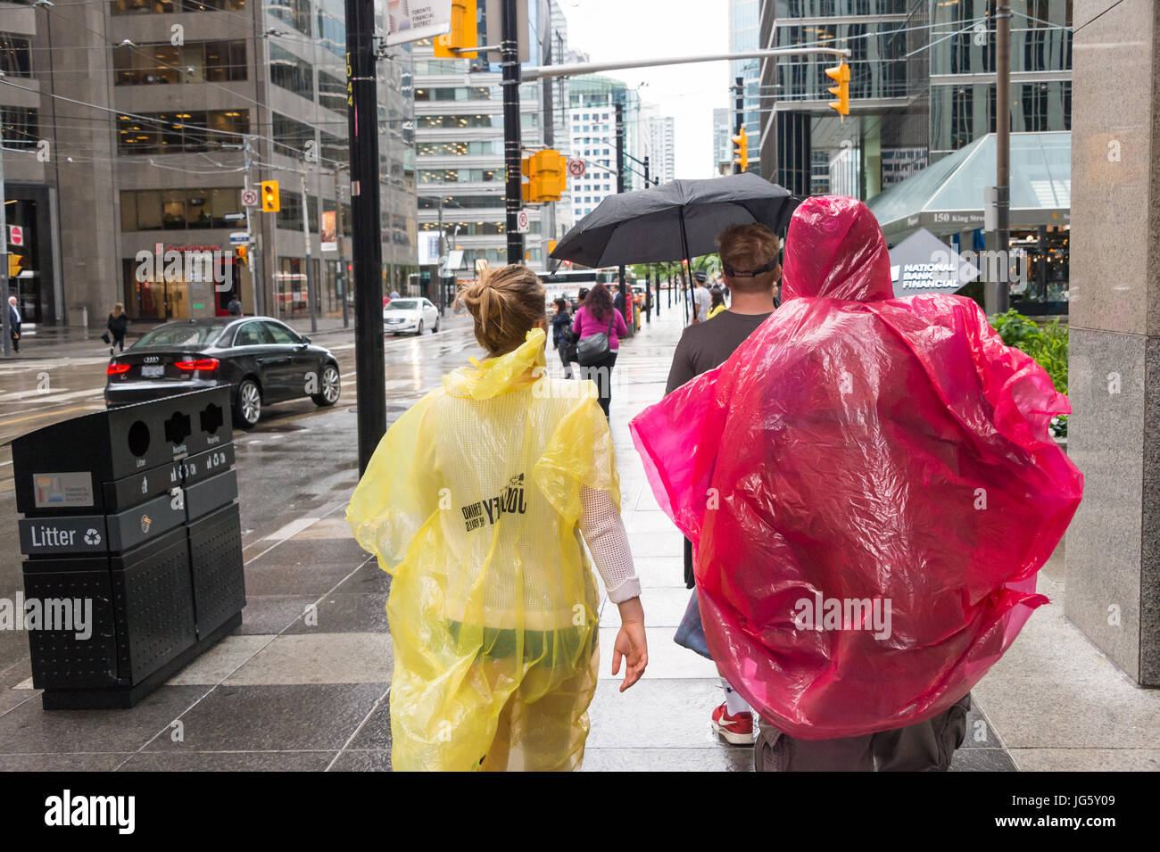 Toronto, Canada - 26 juin 2017 : foule de personnes avec des parapluies et ponchos de pluie un jour de pluie Banque D'Images