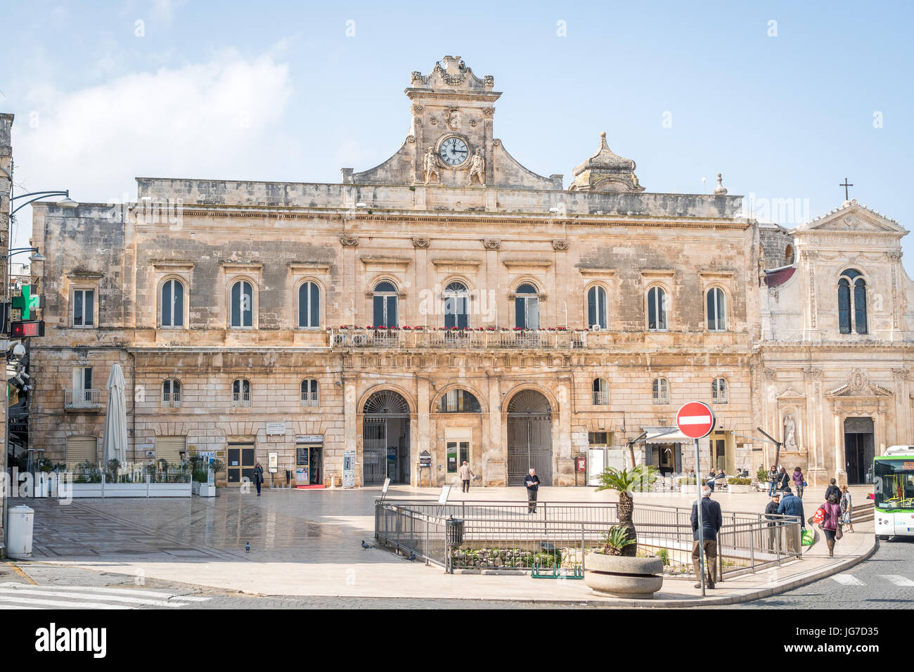 Ostuni, Italie - Février 27, 2017 : l'hôtel de ville d'Ostuni et de l'église et avec les gens de passage. Banque D'Images