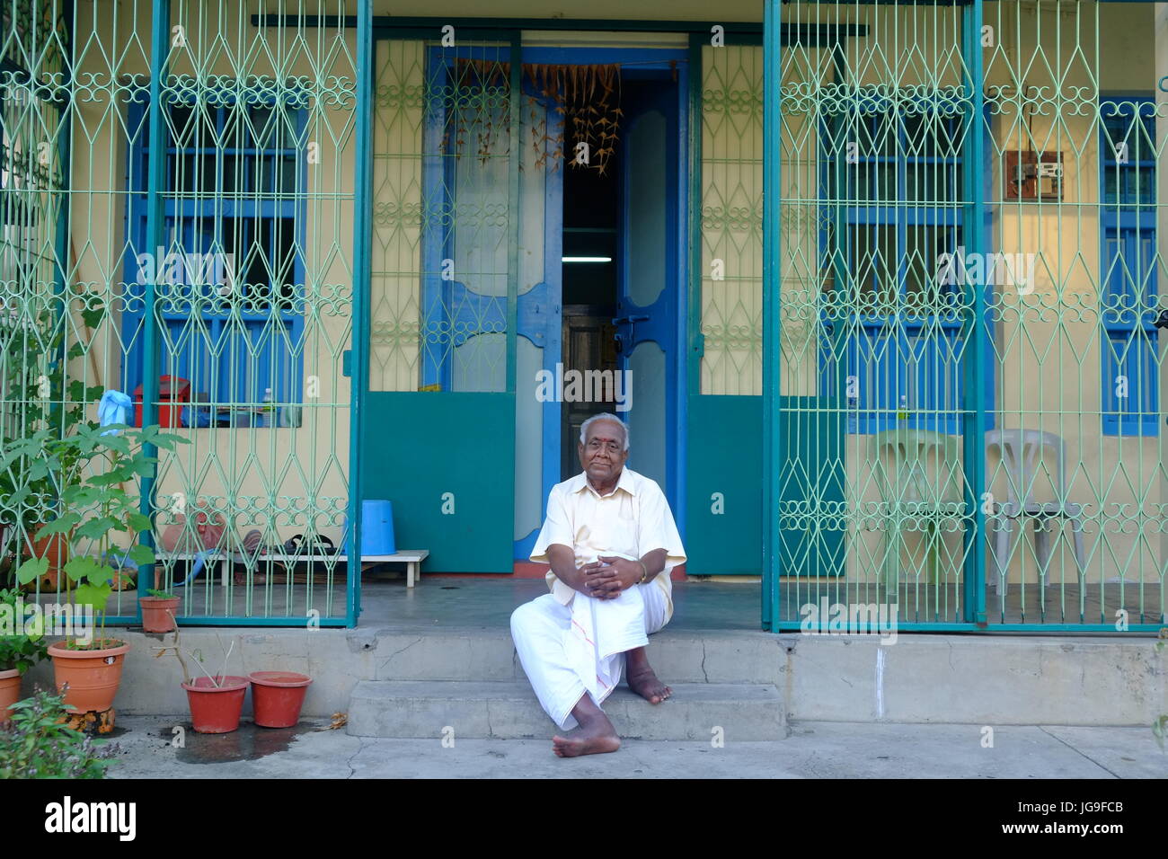 Un homme est assis à l'extérieur d'un vieux bâtiment dans Little India, Georgetown, Penang, Malaisie Banque D'Images