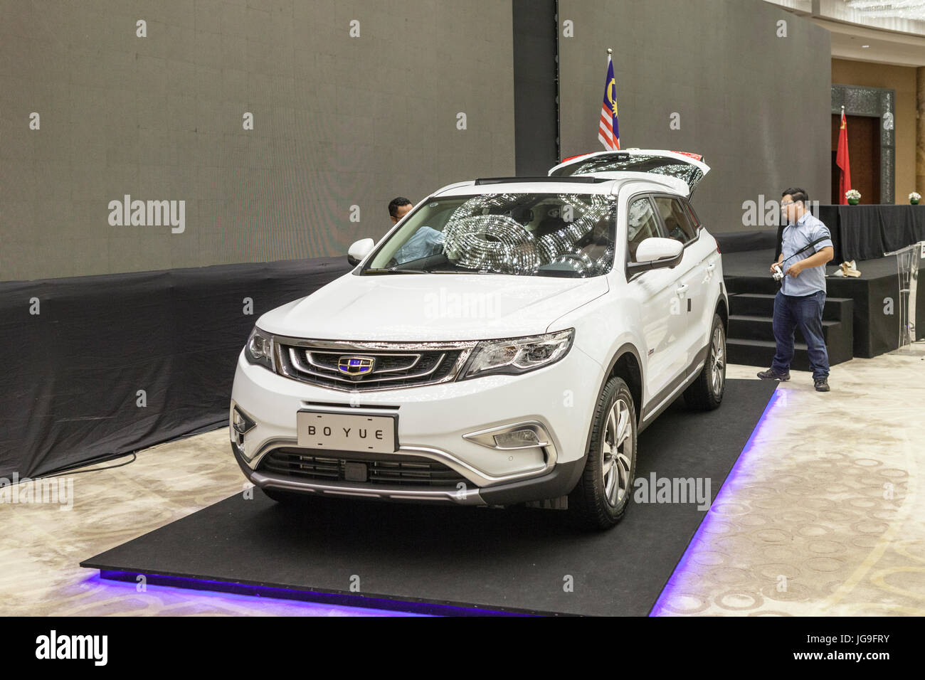 Un membre des médias regardez une Zhejiang Geely Holding Group Co. Boyue véhicule utilitaire sport (VUS) à la suite d'une cérémonie de signature entre la DRB-Hicom Bhd. et Geely à Kuala Lumpur, Malaisie, le vendredi 23 juin, 2017. Banque D'Images