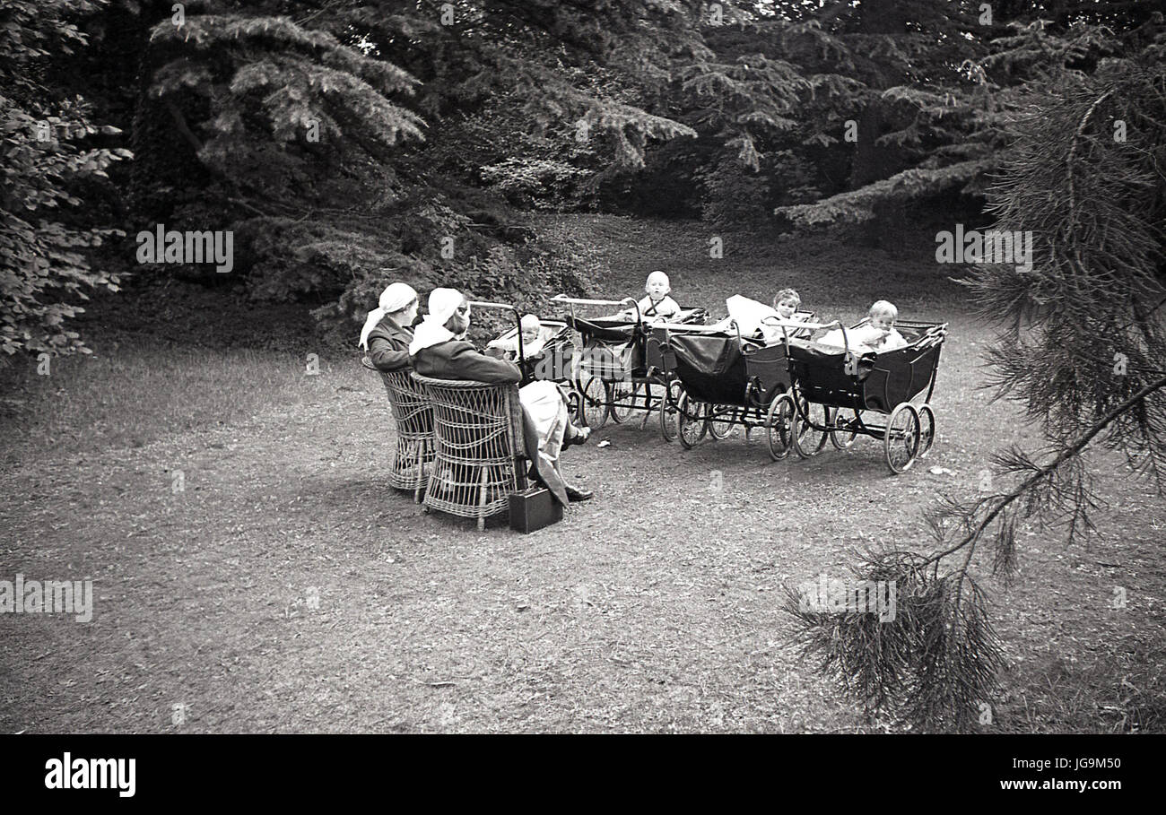 1940, Angleterre, guerre, dans l'enceinte de l'hôtel de Stanstead, demeure de Lady Butler ( Sydney Courtauld) épouse de Rab Butler, homme politique conservateur, deux infirmières s'asseoir à l'extérieur avec l'enfant évacués de Londres en leurs roues chromées poussettes. Banque D'Images