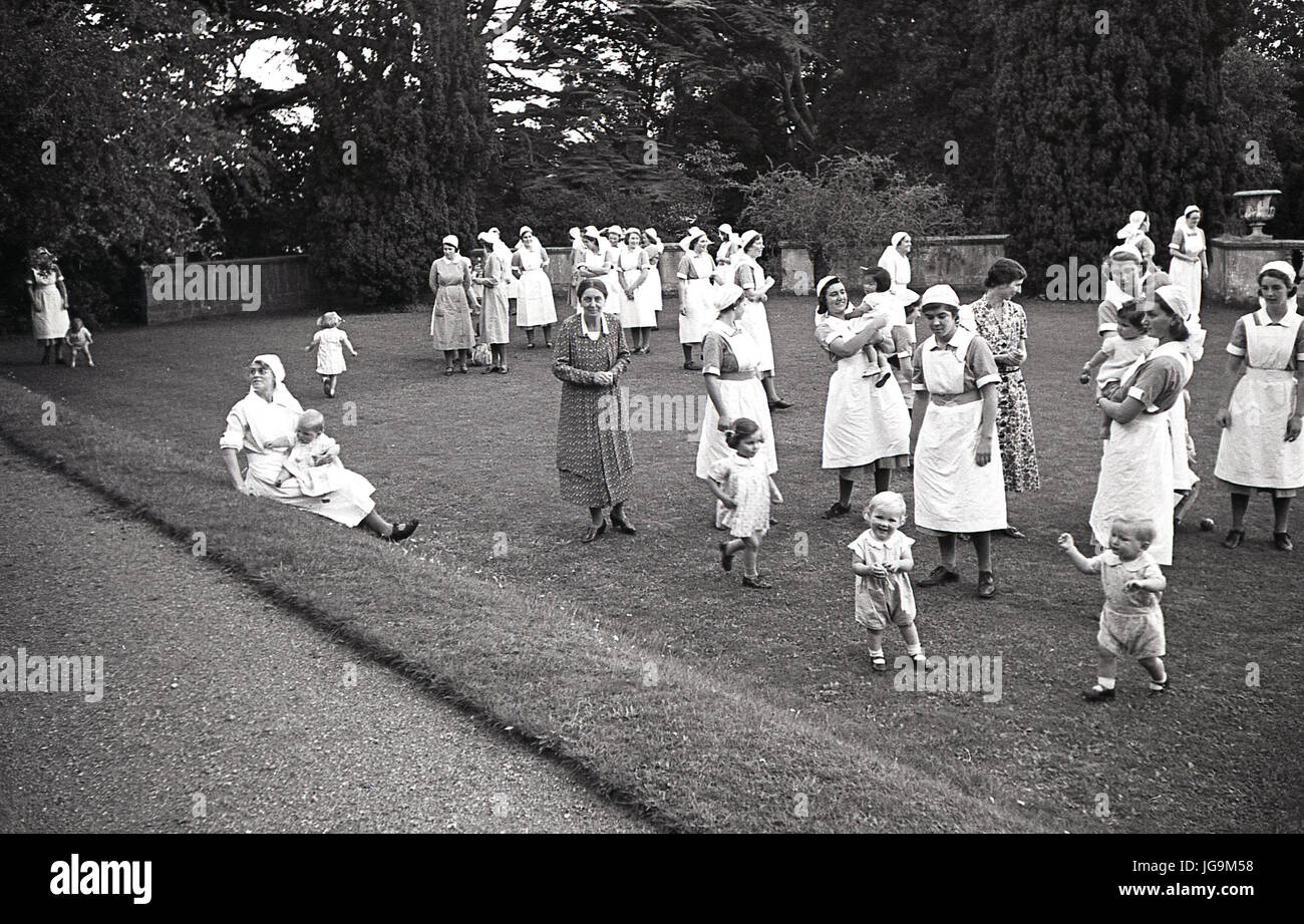 1940, Angleterre, guerre, les infirmières d'enfants dans le parc de Stanstead Hall, maison de Lady Butler (Sydney Courtauld) épouse de Rab Butler, homme politique conservateur, les infirmières étaient là pour s'occuper de l'enfant évacués de Londres qui avait quitté pendant le Blitz. Banque D'Images