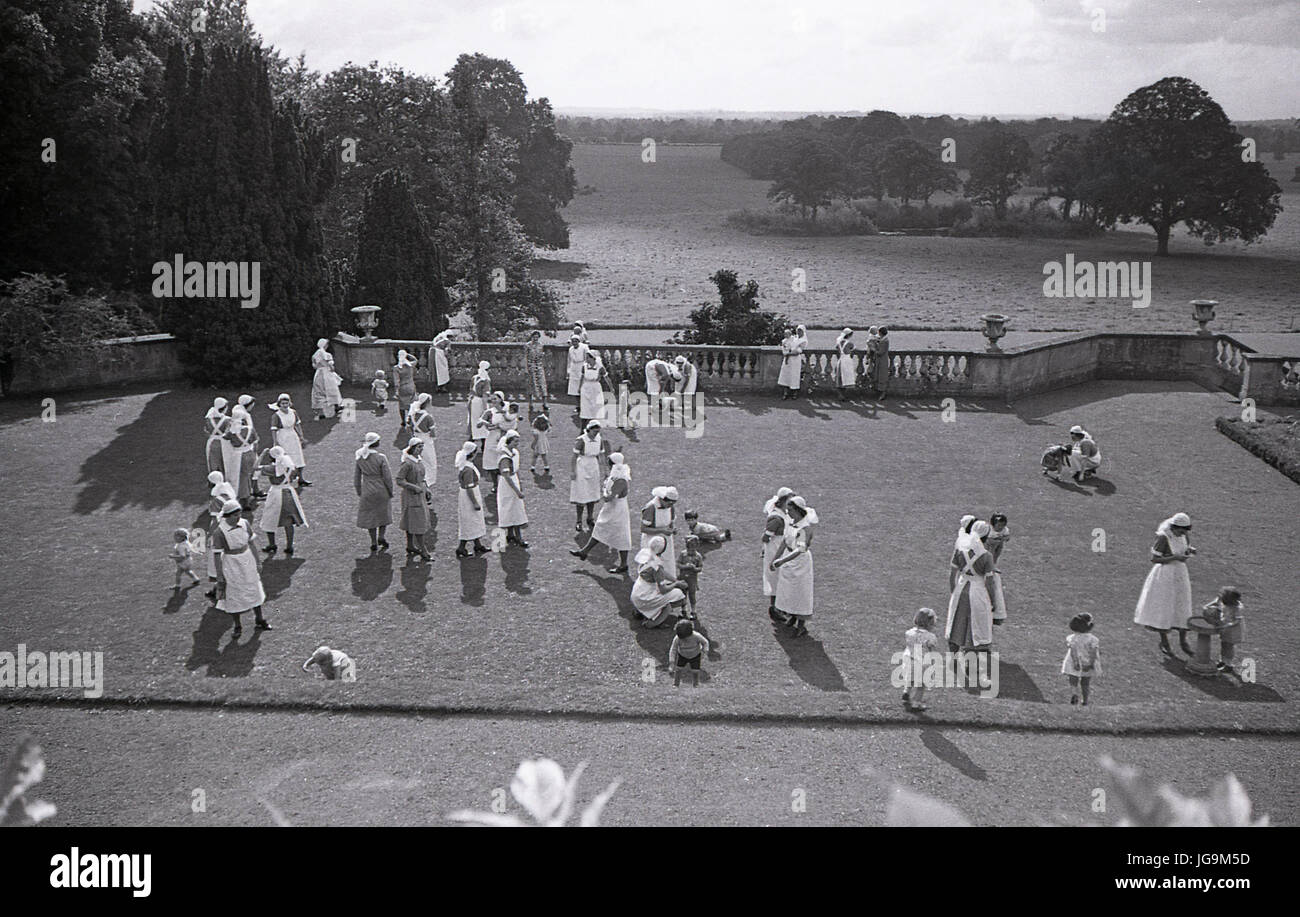 1940, Angleterre, guerre, les infirmières d'enfants dans le parc de Stanstead Hall, maison de Lady Butler (Sydney Courtauld) épouse de Rab Butler, homme politique conservateur, les infirmières étaient là pour s'occuper de l'enfant évacués de Londres qui avait quitté pendant le Blitz. Banque D'Images