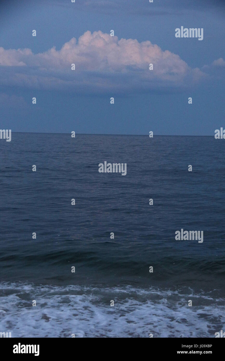 Twilight à la mer avec plage de sable avec des empreintes Banque D'Images