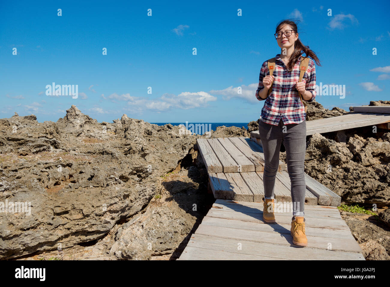 Belle femme asiatique visiter Parc national de Kenting, Taiwan. apprécier les roches rares paysage de mer, balade sur le sentier du bois profiter de vents. Banque D'Images
