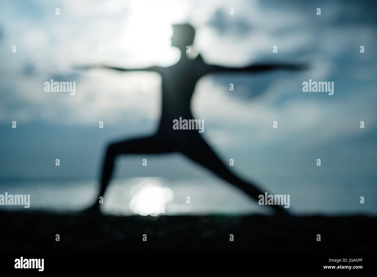 Mettre en place sportive woman faisant l'asana Virabhadrasana 2 guerrier pose posture dans la nature. Banque D'Images