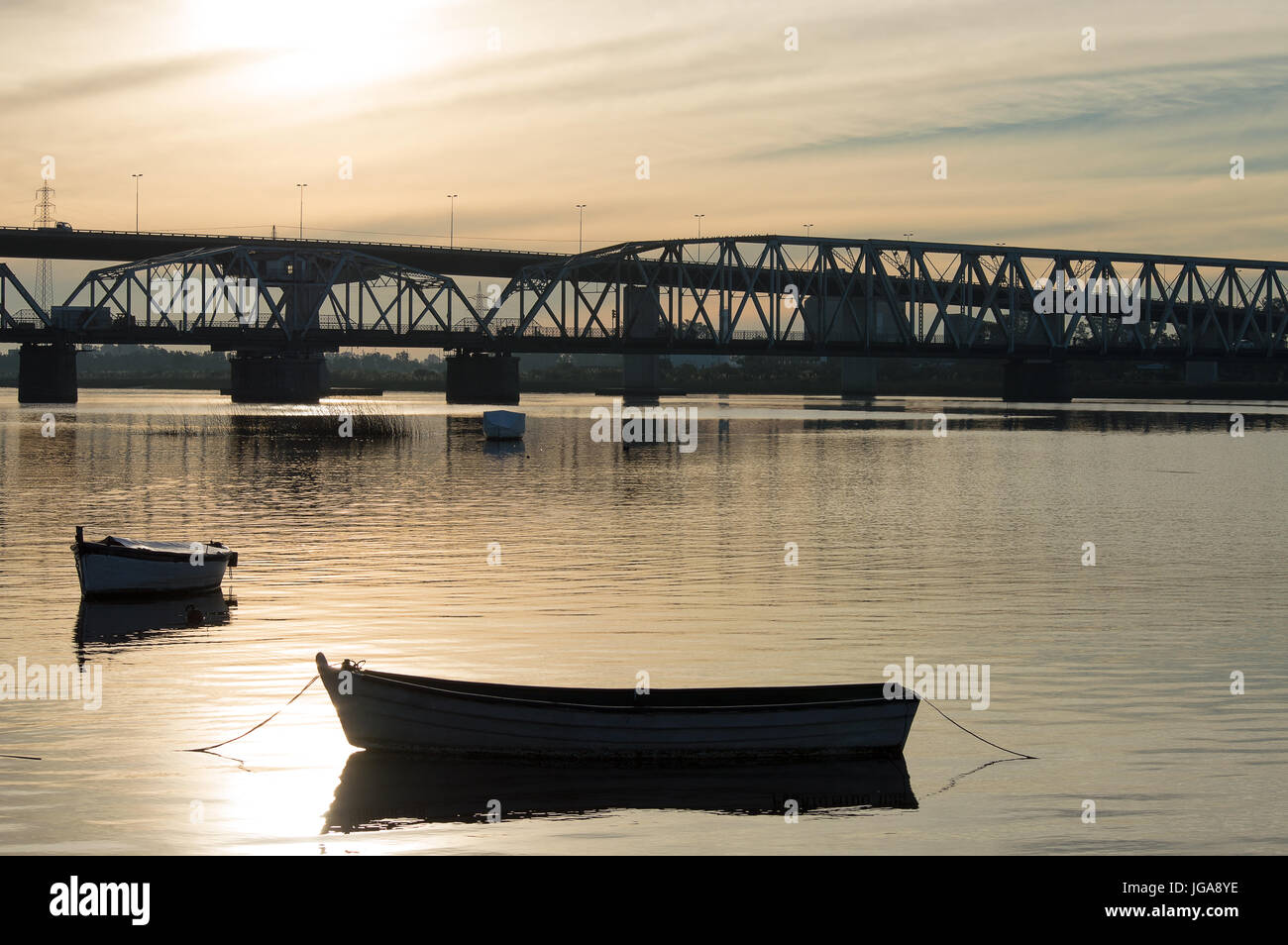 Silhouette du pont et les bateaux sur la rivière Santa Lucia au coucher du soleil en Uruguay Banque D'Images