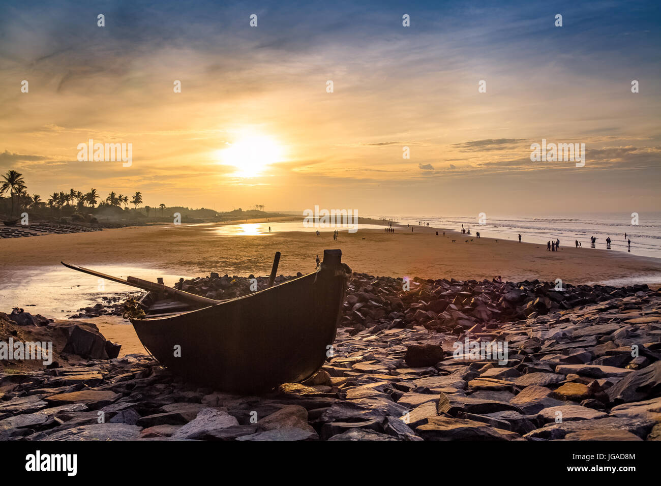 Bateau en bois sur les rochers à la mer plage au lever du soleil avec des moody sky. Banque D'Images