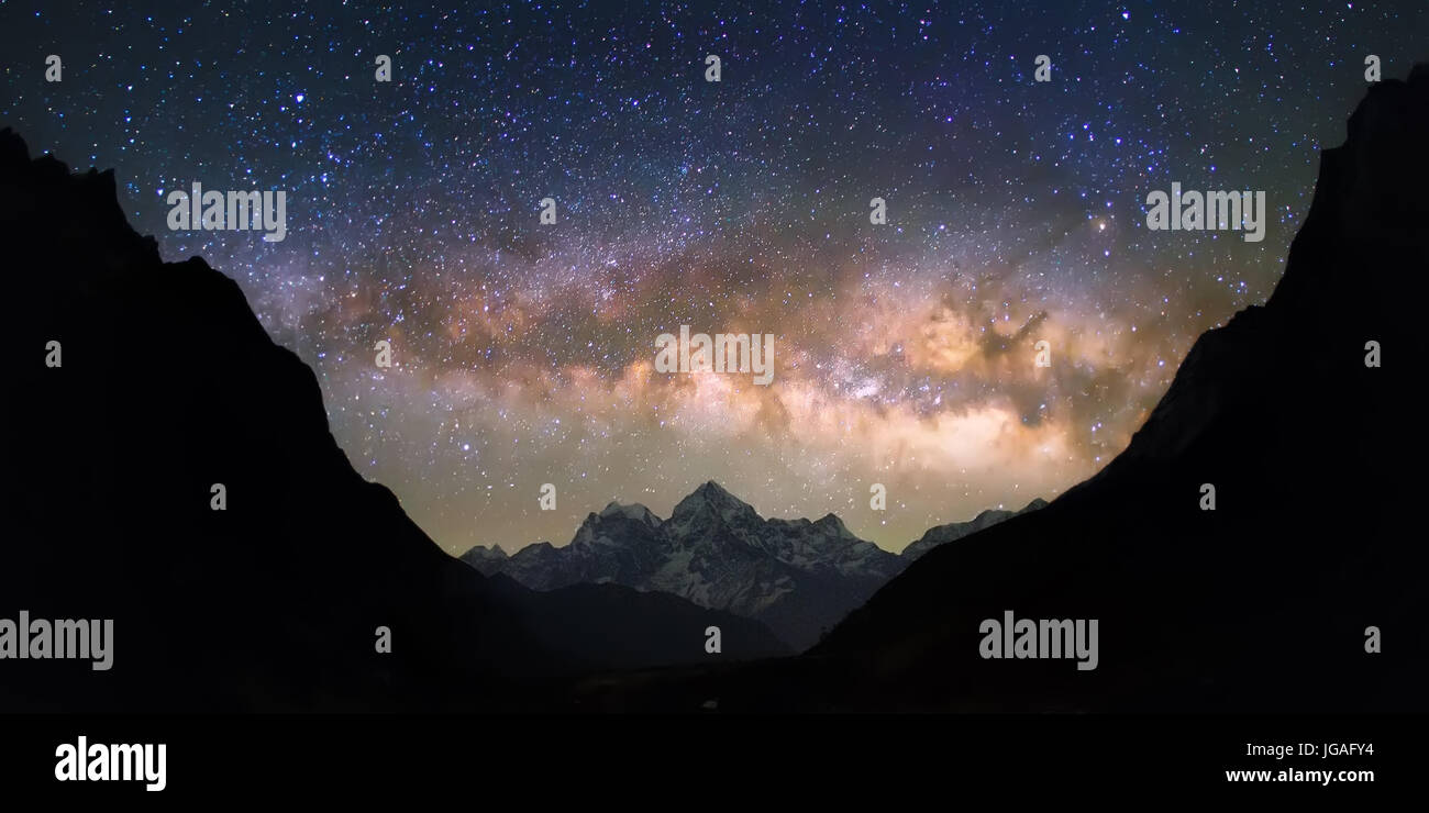 Lumineuses et vives Voie Lactée sur les montagnes enneigées. Le Népal, Himalaya, Everest région, voir de Thamserku peak (6 623 m) de Thame (3800 m). Banque D'Images