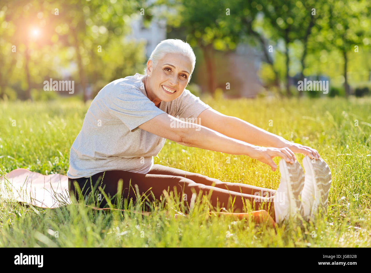 Smiling woman enjoying a pris sa retraite dans les exercices de sport te park Banque D'Images