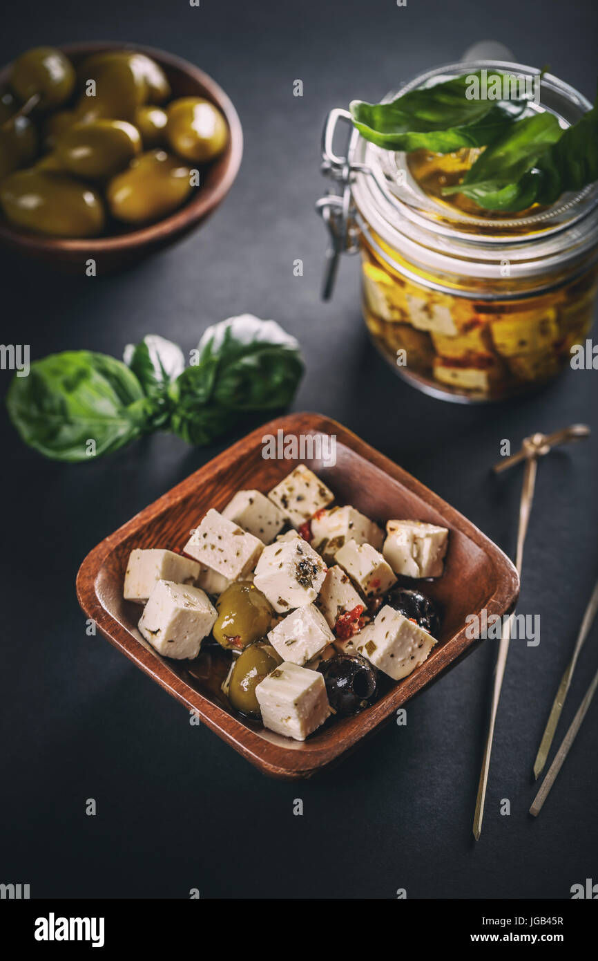 Cubes de fromage feta par des graines d'olive bol en bambou Banque D'Images