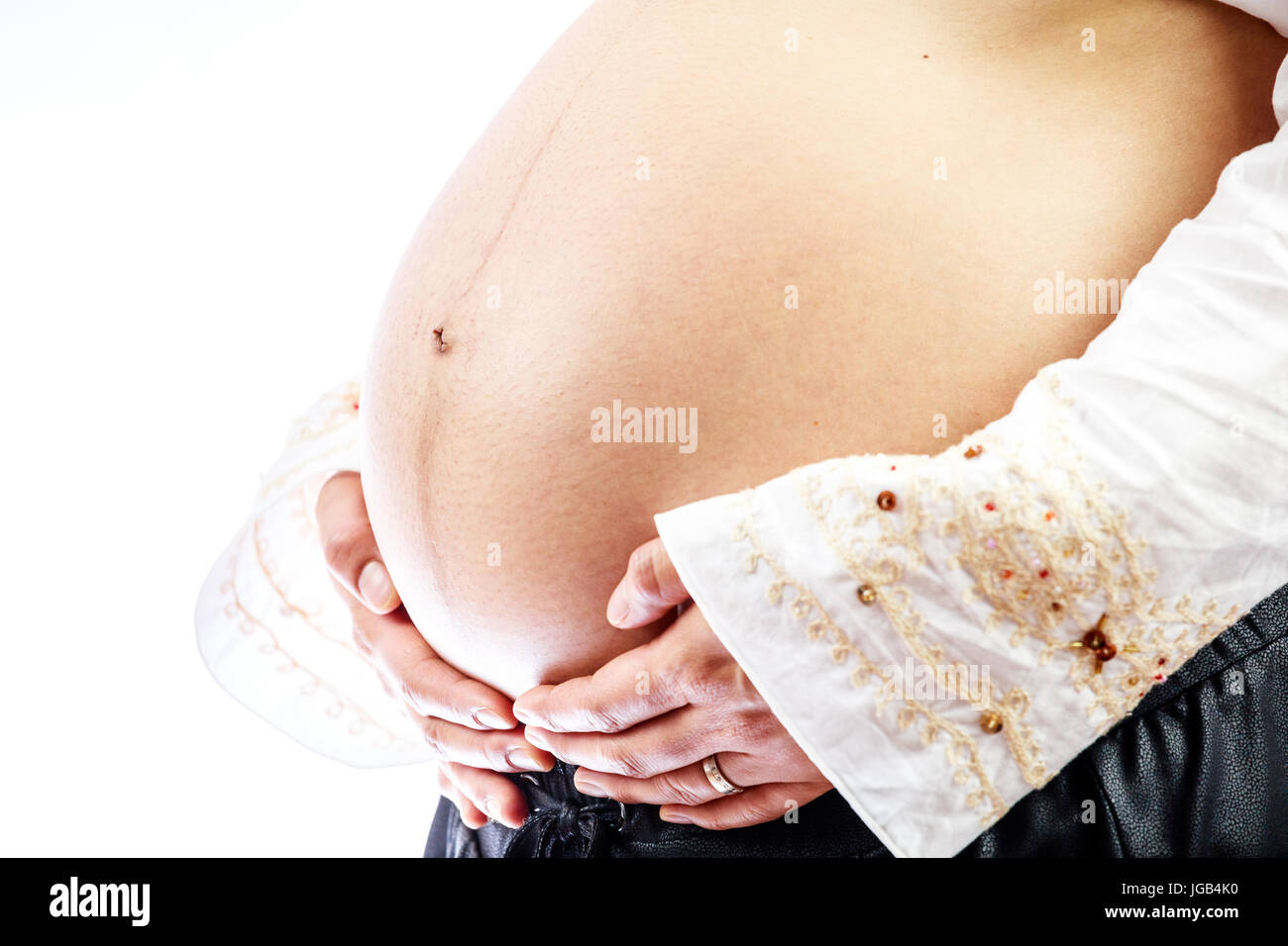 Femme enceinte avec les mains sur son gros ventre Banque D'Images