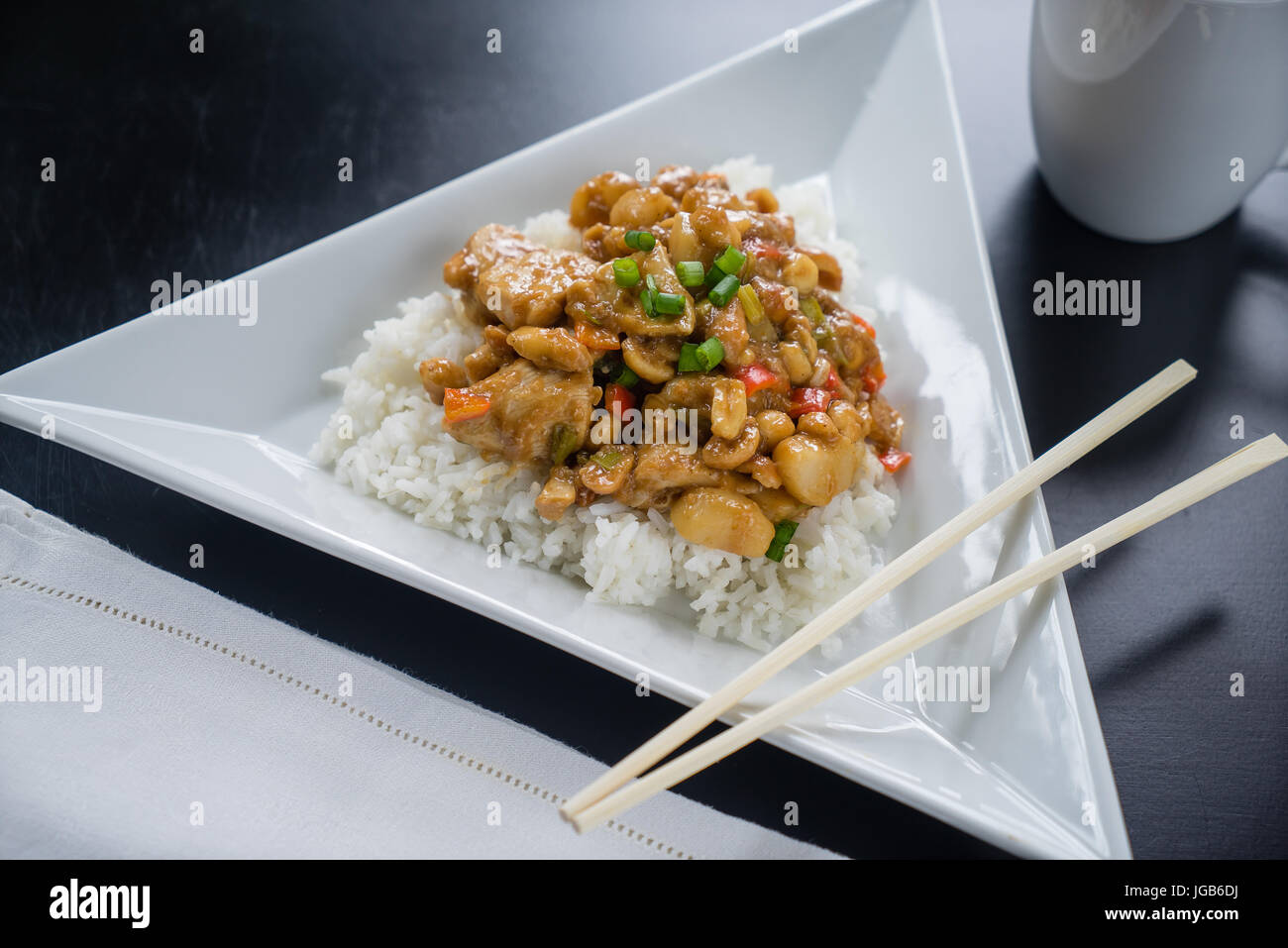 Assiette de poulet Kung Pao sur plaque blanche avec des baguettes. Banque D'Images