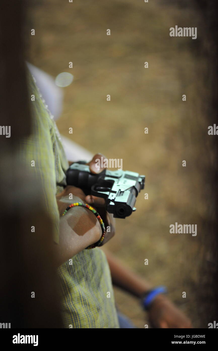 Jeune garçon détient des armes réalistes au festival en Amérique centrale Banque D'Images