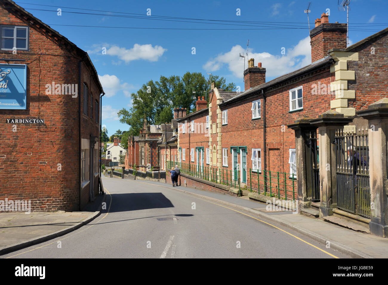 Un couple de personnes âgées marcher dans Bargates dans le Shropshire historique et pittoresque ville de Whitchurch sur une belle journée d'été. Banque D'Images