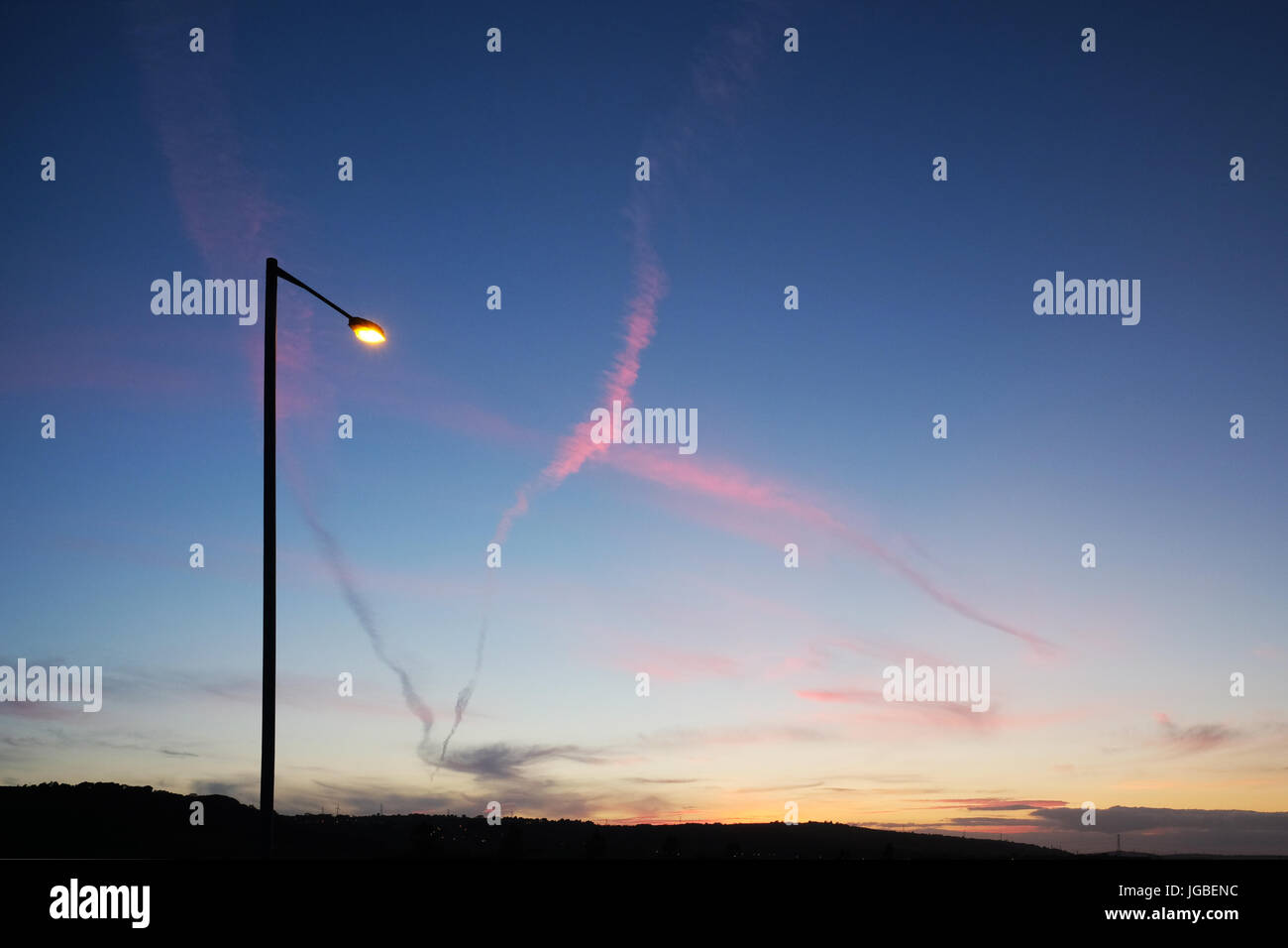 Street light & jet trails at Dusk, Whitehead, L'Irlande du Nord. Banque D'Images