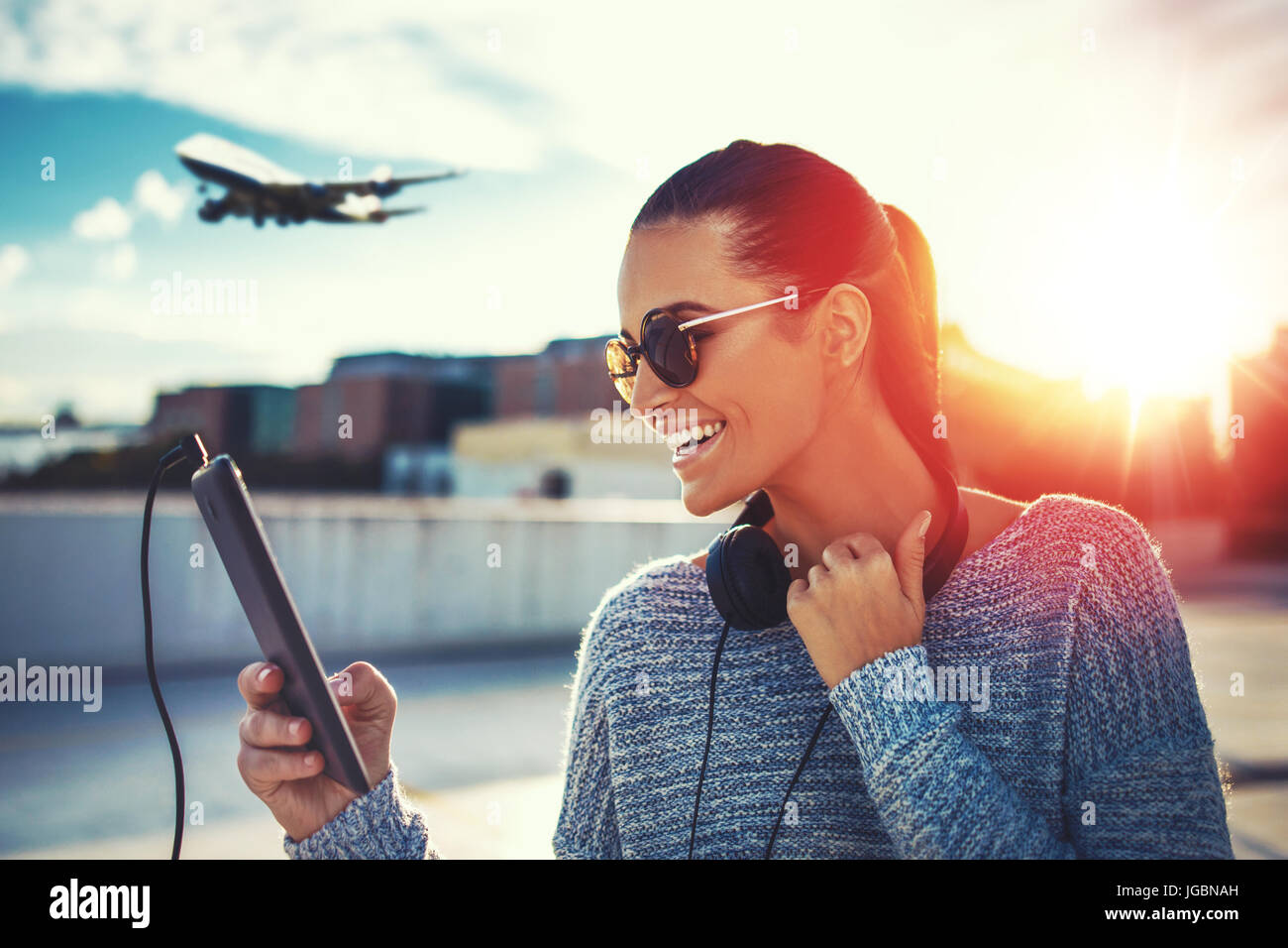 Jeune femme heureuse d'air comprimé par l'achat de billets, une dans le coucher du soleil Banque D'Images