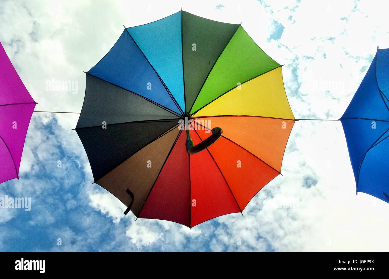 Couleur arc-en-ciel parapluie sur le fond bleu ciel nuageux à Gdynia, Pologne Banque D'Images