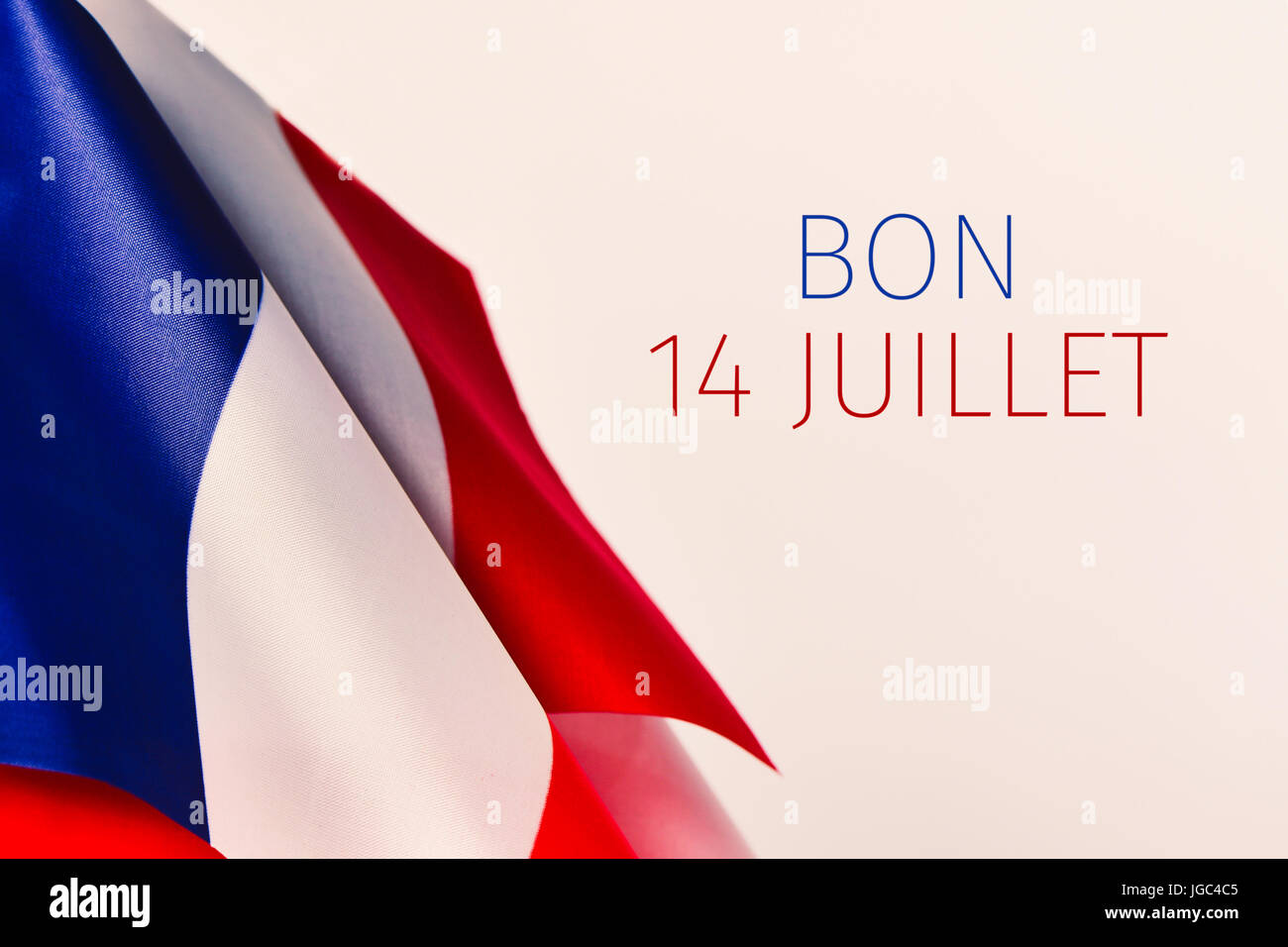 Quelques drapeaux français et le texte texte bon 14 juillet, 14 juillet, la Journée nationale de France écrit en français, contre un fond blanc Banque D'Images