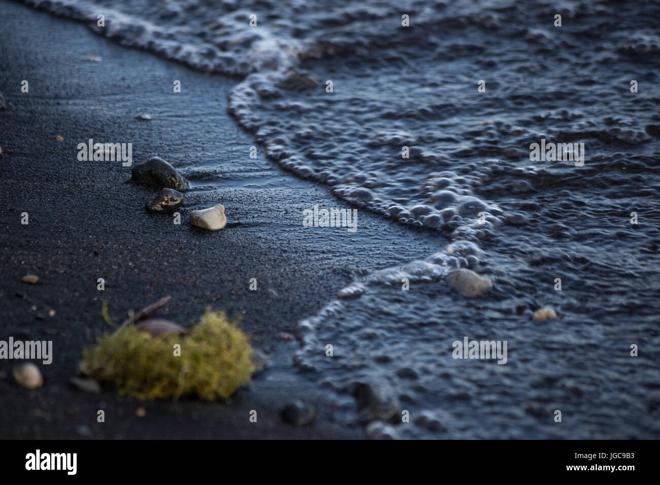 Un coup d'eau sur un lac, avec des détails de bulles et peu de pierres sur le sable Banque D'Images
