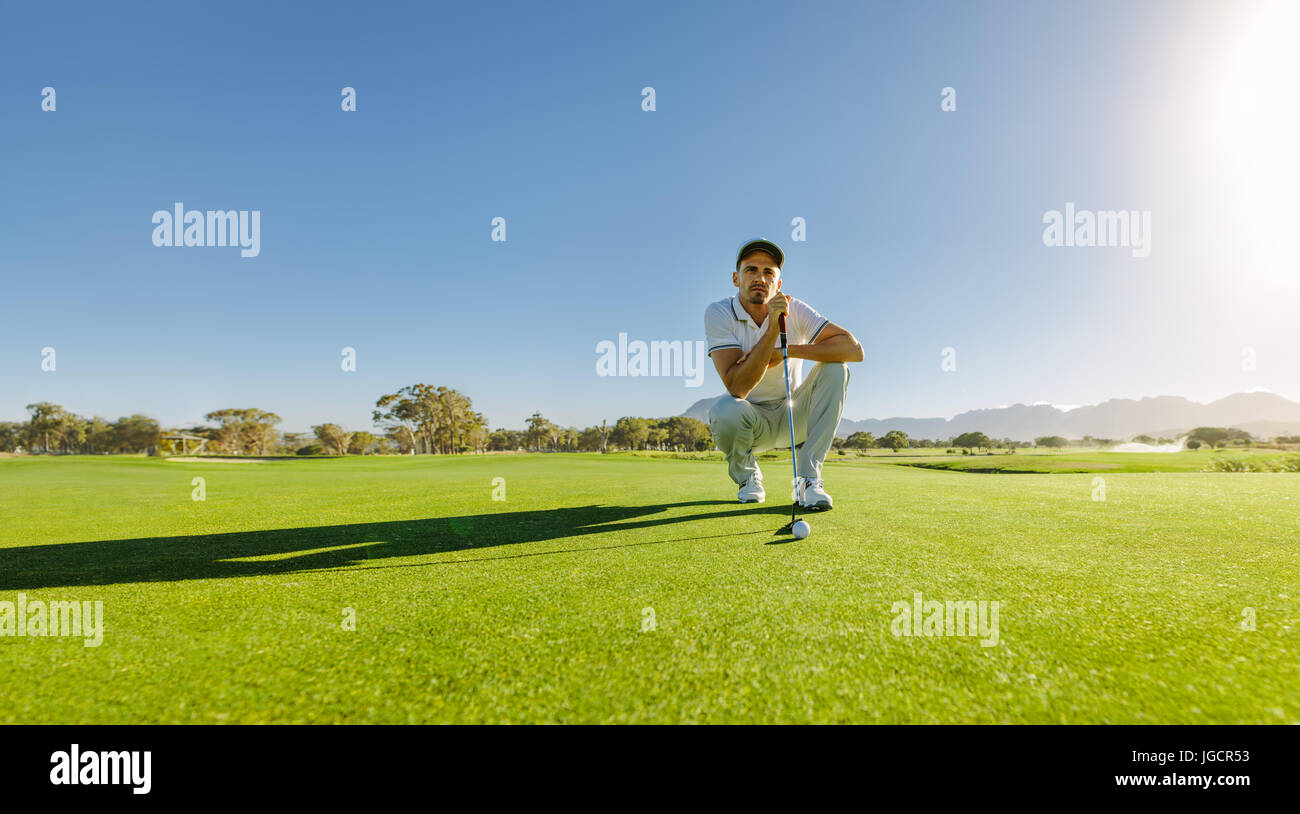 Joueur de golf pro shot club avec vue sur cours. Male golfer sur putting green sur le point de prendre la photo. Banque D'Images