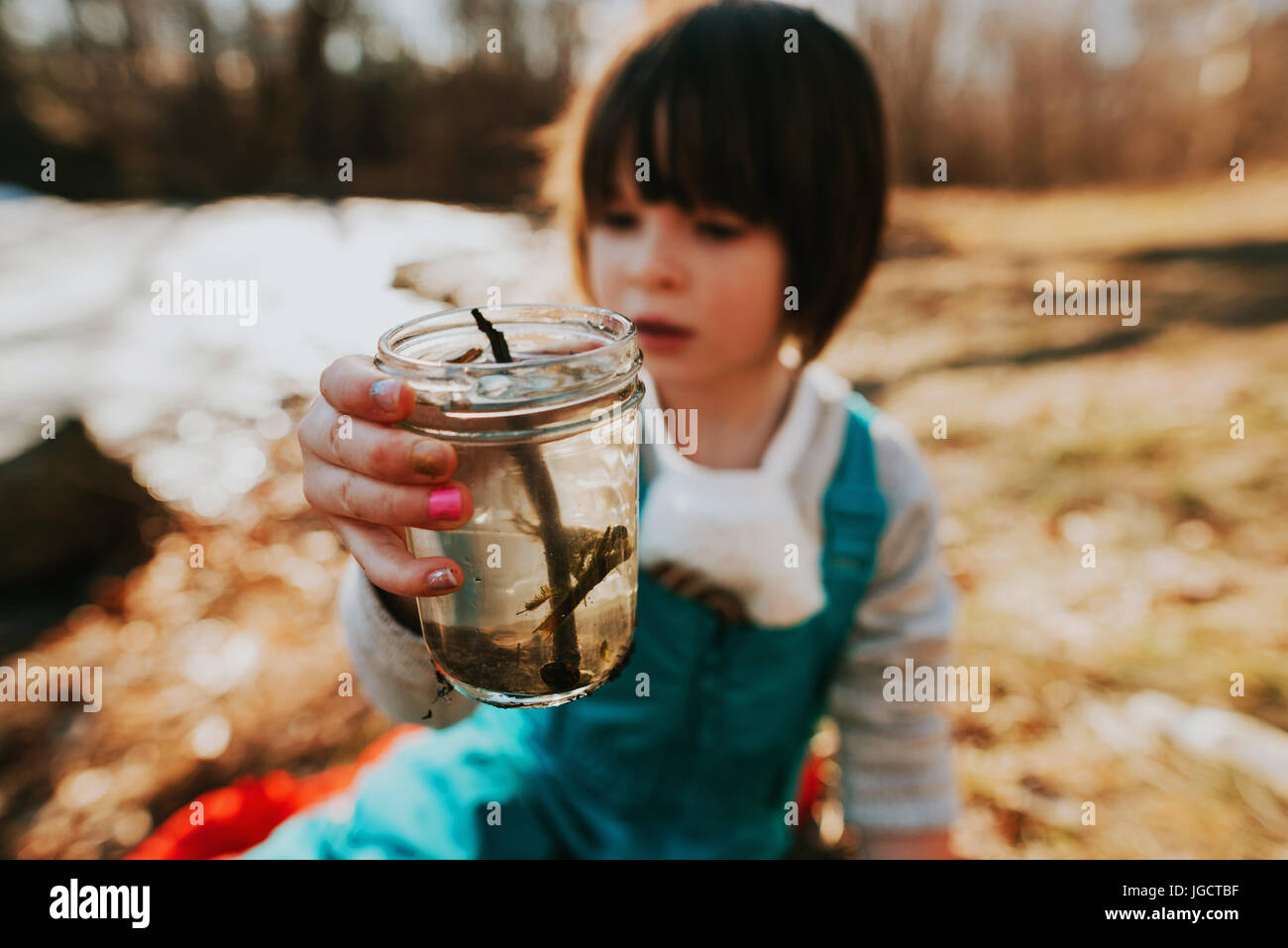 Girl holding un pot avec de l'eau bugs Banque D'Images