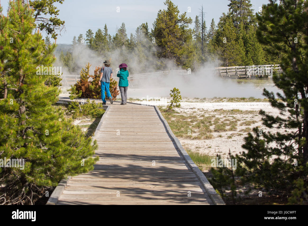 Un couple (homme et femme) marche sur la promenade de West Thumb Geyser Basin dans le Parc National de Yellowstone Banque D'Images