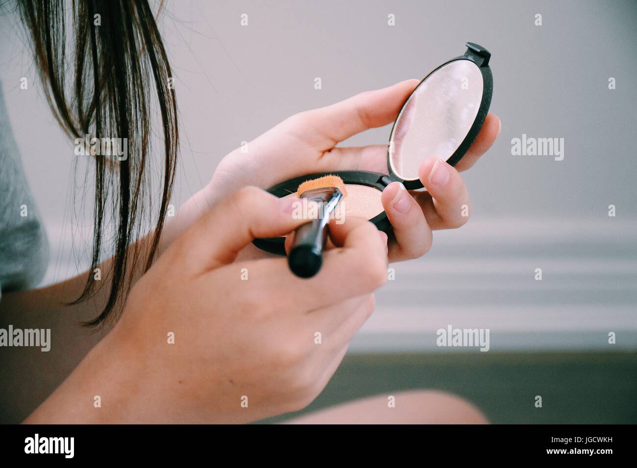 Teenage girl applying make-up Banque D'Images