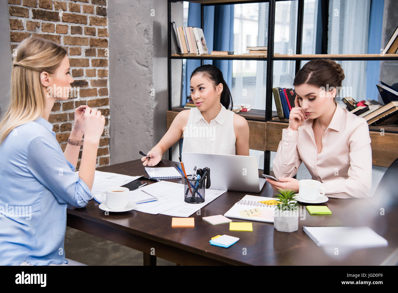 Trois affaires multiculturelles et de discuter sur le lieu de travail du projet in modern office Banque D'Images