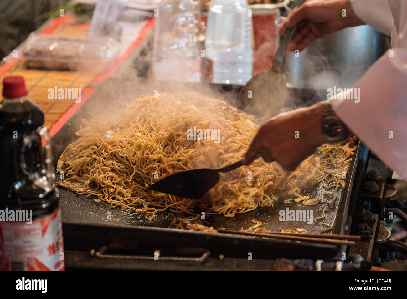 Un vendeur alimentaire préparation yakisoba au cours d'un festival japonais pendant l'été. Banque D'Images