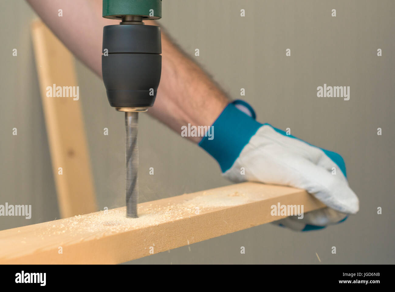 Carpenter handyman en utilisant la perceuse électrique pour faire des trous sur la planche sur la table de l'atelier de menuiserie Banque D'Images