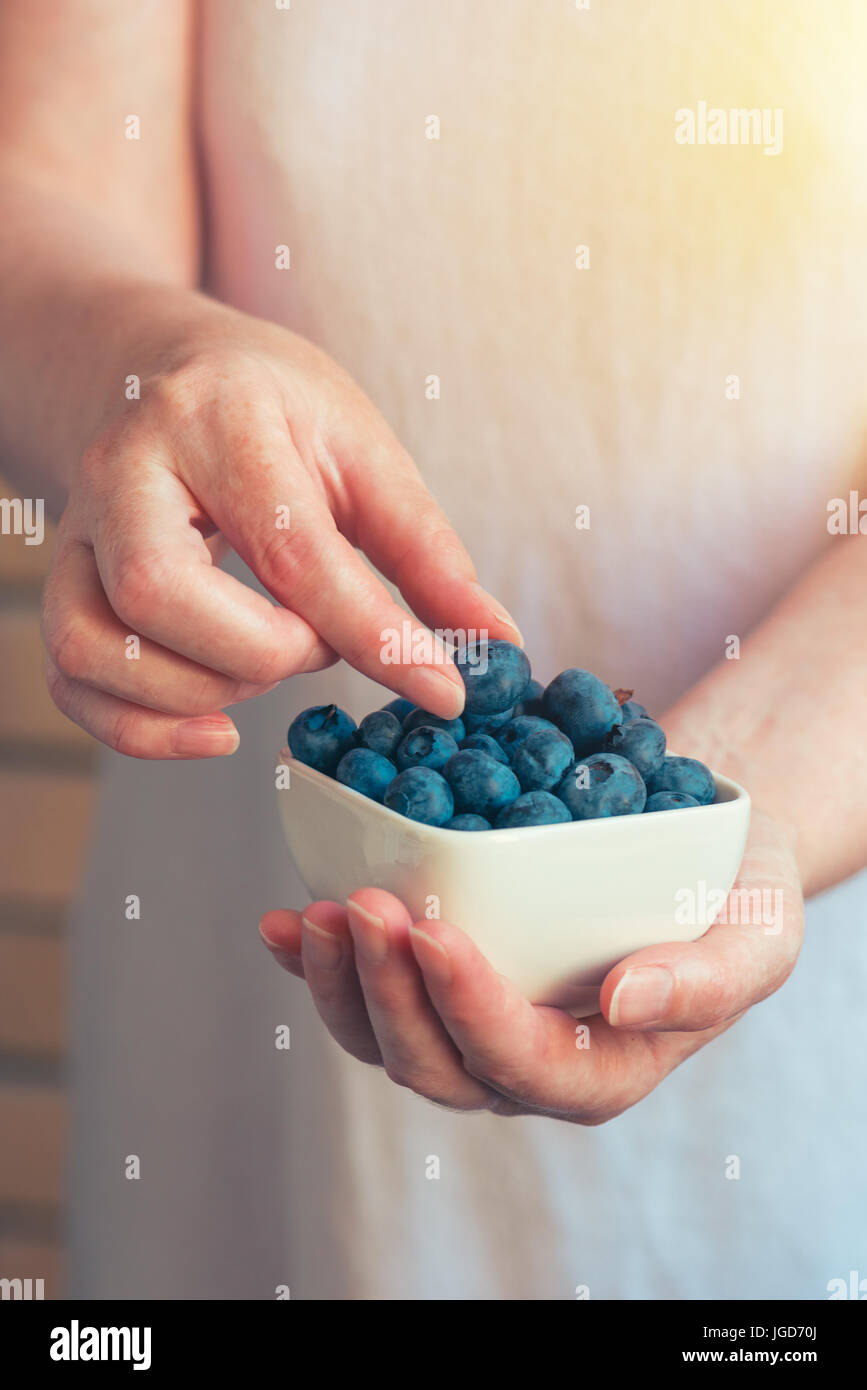 Femme offrant des bleuets, mûres de petits fruits frais bio Banque D'Images