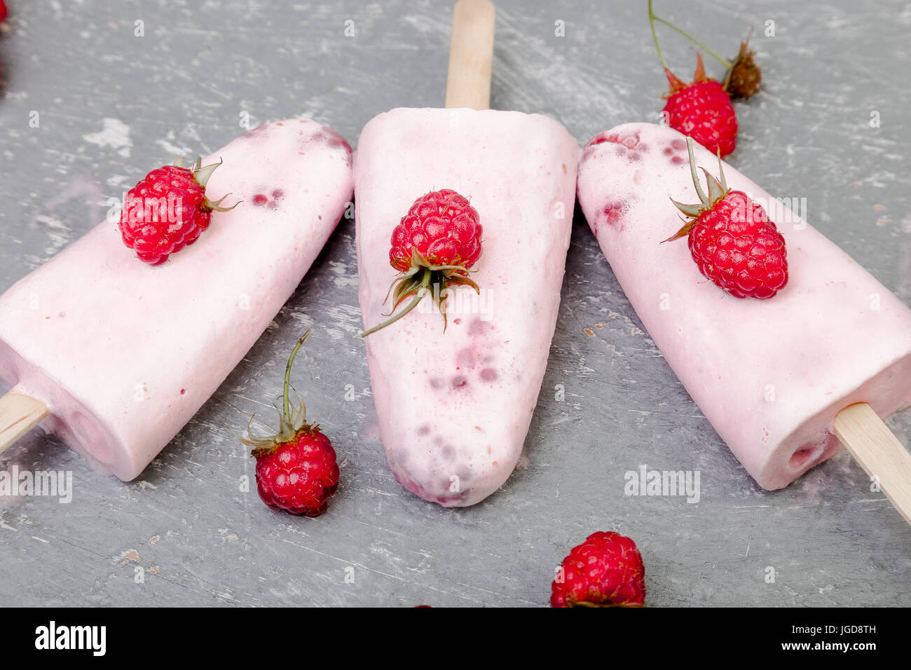 Glace à la framboise sur fond gris. Trois sucettes glacées. vue d'en haut. des Banque D'Images