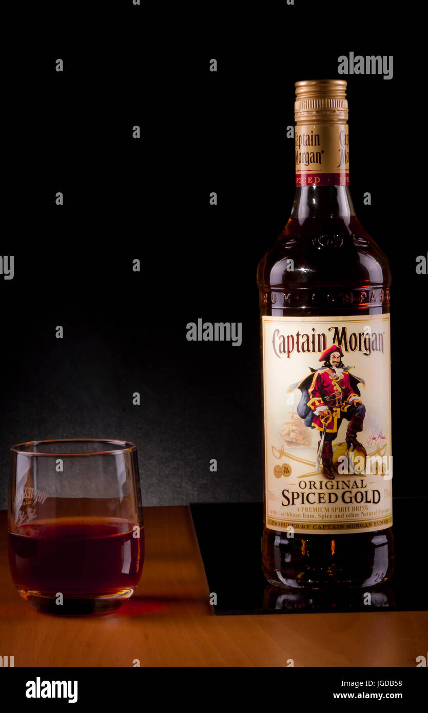 Une bouteille d'épices original Captain Morgan, avec un verre sur la gauche. Banque D'Images